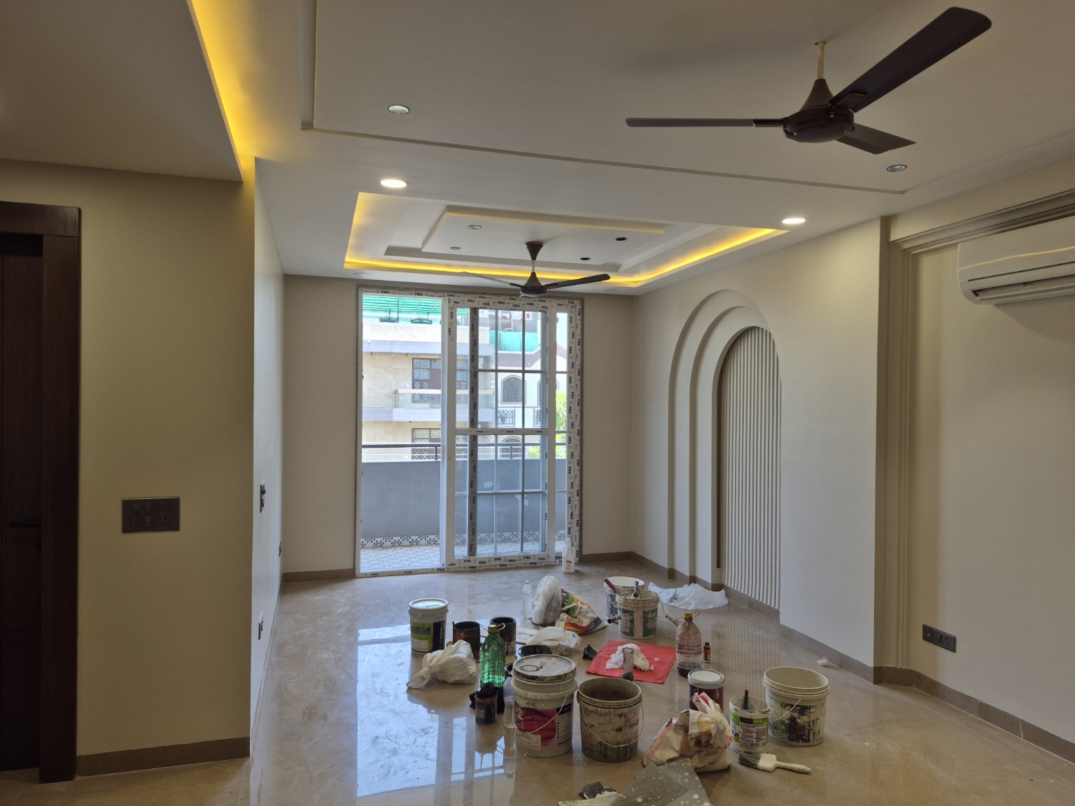 Arched wall detail, ceiling lighting and painting materials at Sector 23, Gurugram — work ongoing